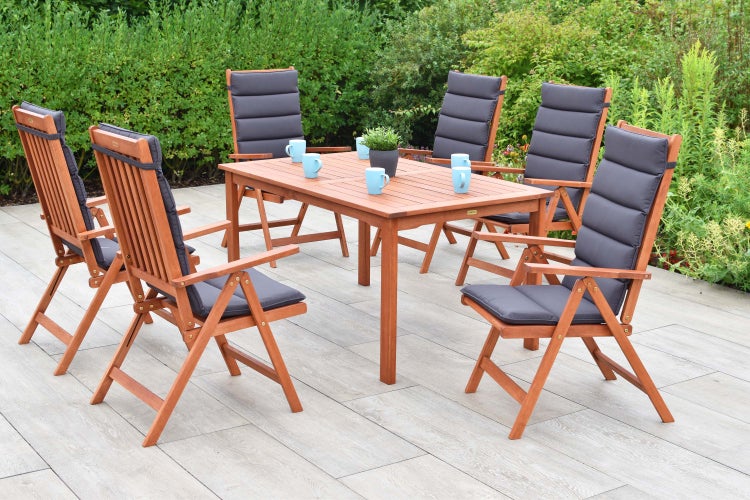 Holz Gartentisch mit sechs Stühlen und grauen Auflagen im Garten