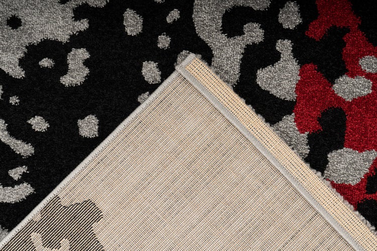 Teppich mit Leopardenmuster in Schwarz, Grau und Rot, Detailansicht der Oberfläche und der gewebten Rückseite.