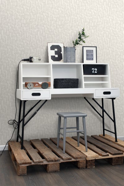 Einrichtungsszene mit einem weißen Schreibtisch mit Regalen, einem grauen Hocker und Paletten