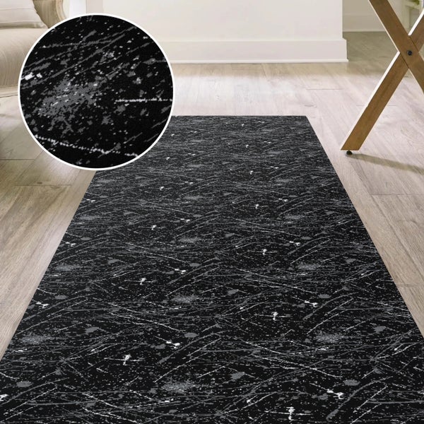 Schwarzer Teppich mit abstraktem Muster auf Holzboden
