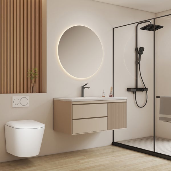 Modernes Badezimmer mit hängender Toilette, beigem Waschtisch, rundem beleuchtetem Spiegel und Dusche mit schwarzen Armaturen.
