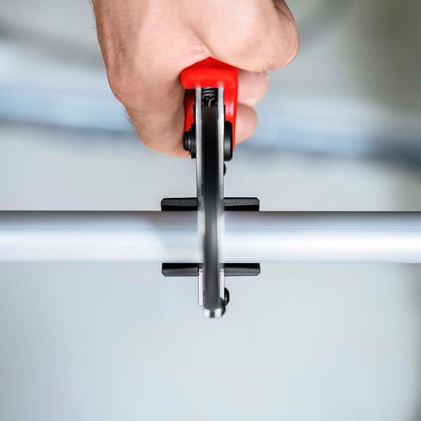 Eine Rohrzange schneidet ein Metallrohr.