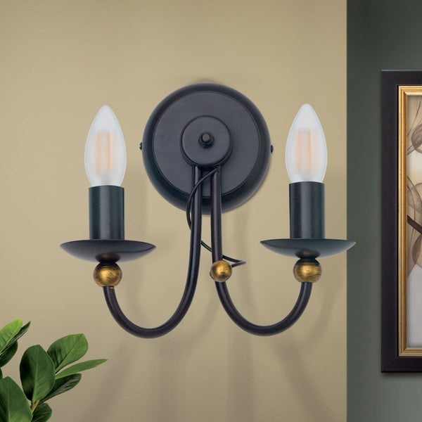 Zweiflammige Wandleuchte im Landhausstil aus Metall mit geschwungenen Armen und Kerzenoptik.