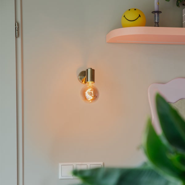 Wandleuchte mit runder Glühbirne in einem Wohnraum