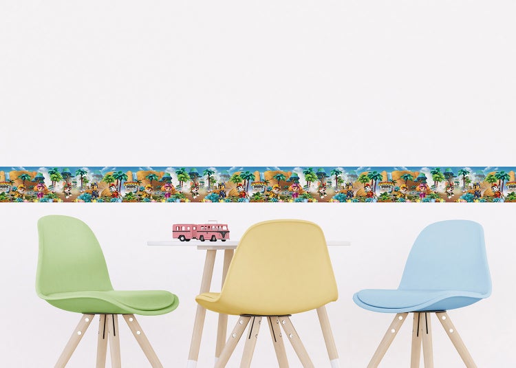 Wandborte Paw Patrol Jungle Pups mit Dschungel-Motiv an einer Wand in einem Kinderzimmer über einem Tisch mit bunten Stühlen.