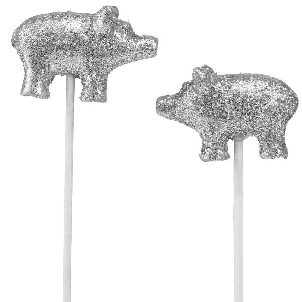 Zwei glitzernde Schweinefiguren auf Stäben als Dekoration