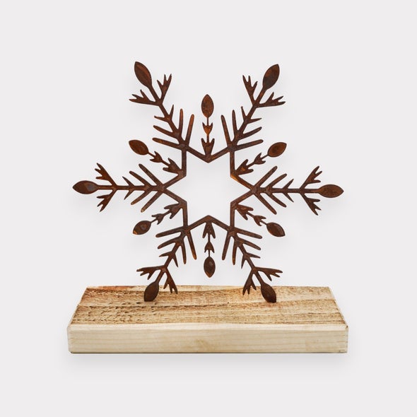 Dekorative Schneeflocke aus Metall auf Holzsockel