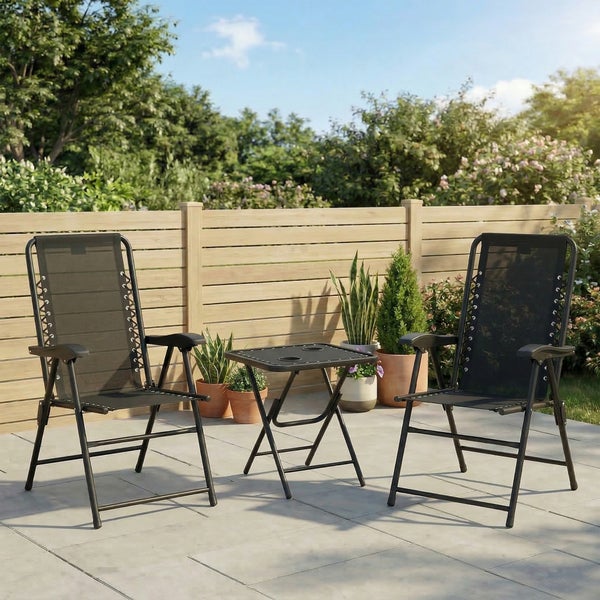 Gartenmöbel-Set bestehend aus zwei schwarzen Klappstühlen und einem Klapptisch auf einer Terrasse vor einem Holzzaun.