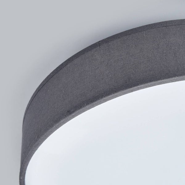Detailansicht einer runden Deckenleuchte mit grauem Textilschirm und weißem Diffusor.