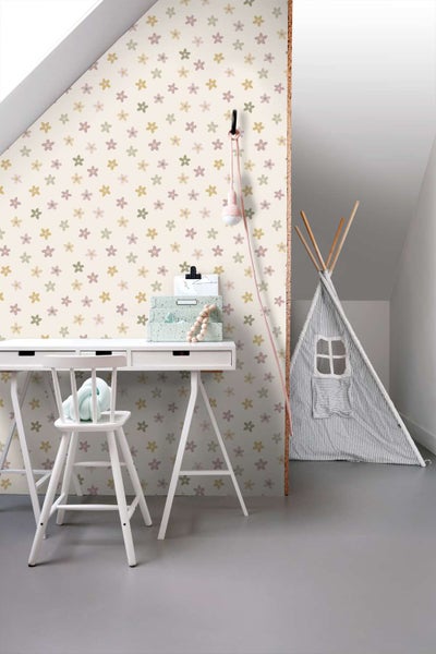 Kindertapete mit Blumenmuster an einer Wand im Kinderzimmer mit einem Schreibtisch, einem weißen Kinderstuhl und einem Spielzelt im Hintergrund.