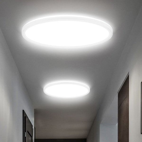 Zwei flache, runde LED-Deckenleuchten in einem hell beleuchteten, modernen Flur.