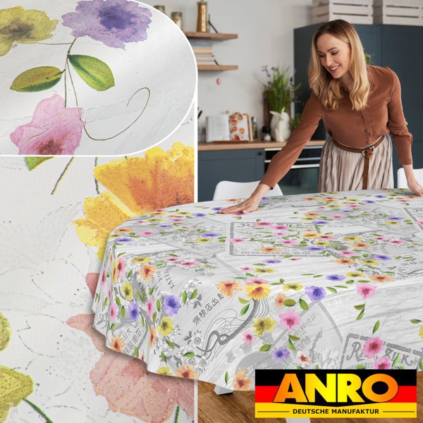 Ovale Tischdecke mit floralem Muster und Vintage-Motiven auf einem Küchentisch, ANRO Logo.
