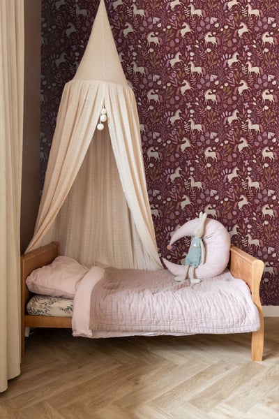Kinderzimmer mit Himmelbett und Tapete mit Einhornmuster