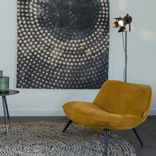 Wohnzimmer mit Sessellampe, Kunst und rundem Teppich