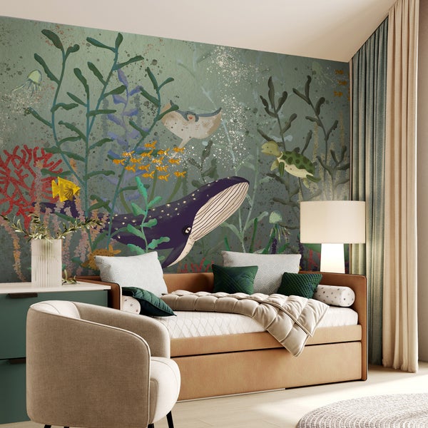 Kinderzimmer mit Bett, Sessel, Kommode, Vorhängen und einer Wandtapete mit Unterwassermotiv