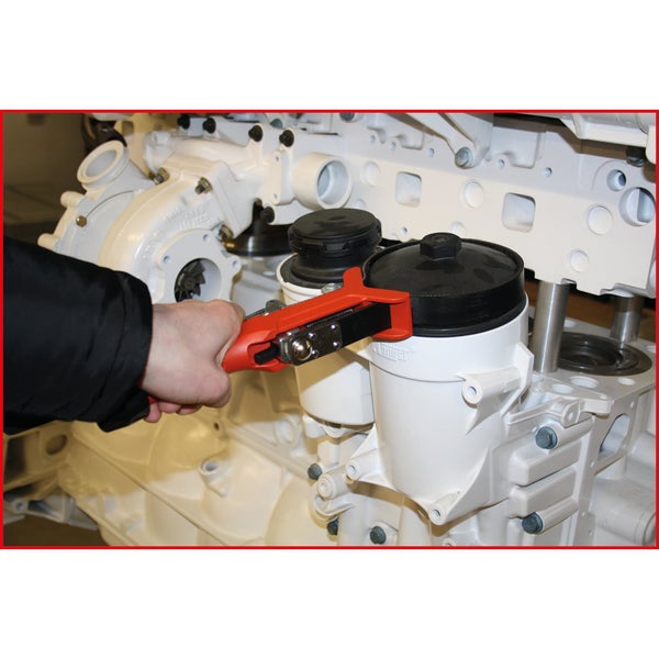 Hand benutzt Ölfilterschlüssel an Motor