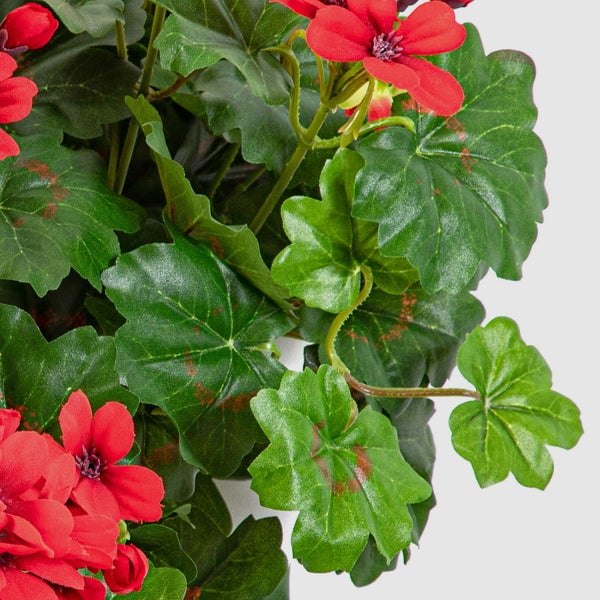 Detailansicht einer künstlichen Geranie mit roten Blüten und grünen Blättern