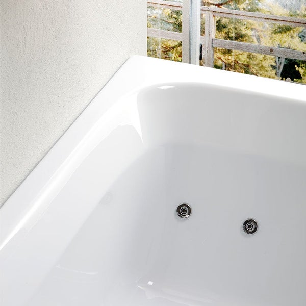 Detailaufnahme einer weißen Badewanne mit Düsen und Blick aus dem Fenster