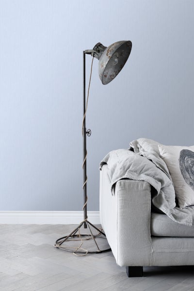 Stehlampe im Industrie-Design neben einem Sofa