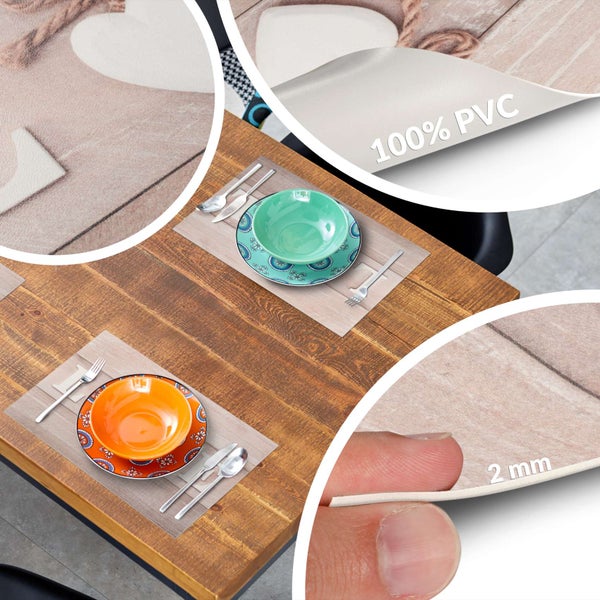 Platzset aus 100 Prozent PVC mit Holzoptik und Herz-Motiv, 2 Millimeter dick, auf einem Holztisch mit Tellern und Besteck.