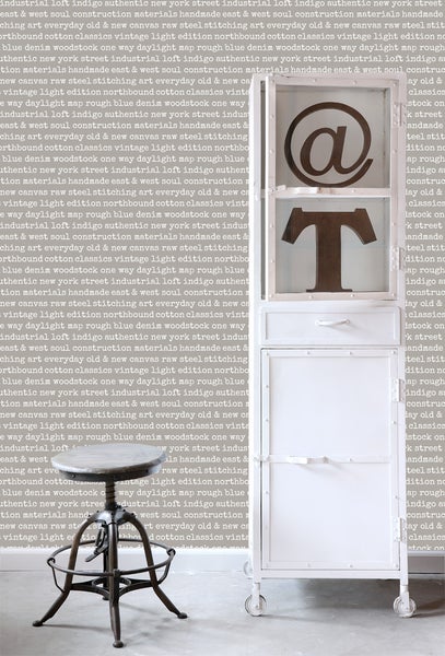 Raumansicht mit einem Regal mit Fächern und Schubladen und einem Barhocker