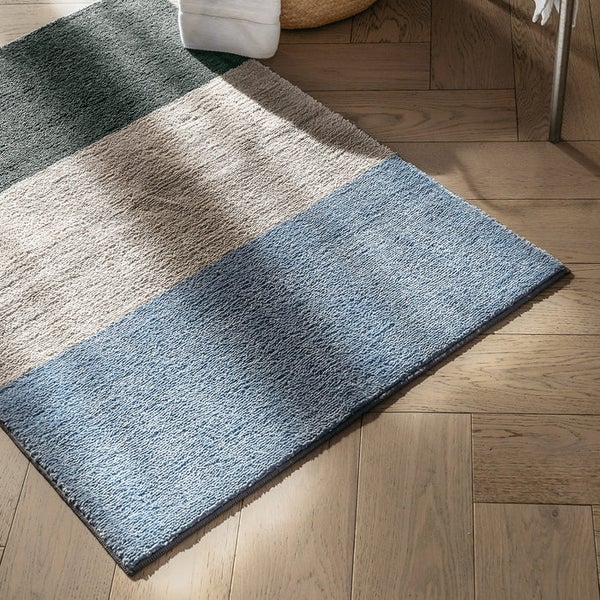 Mehrfarbige Badematte auf Holzboden