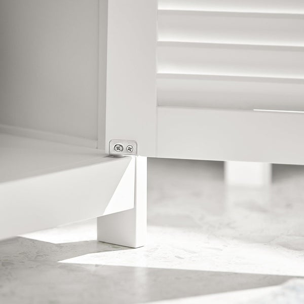 Detailansicht eines weißen Badezimmerschranks mit Lamellentüren und Eckverbindung