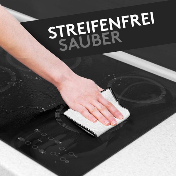 Eine Hand reinigt ein Kochfeld mit einem Reinigungstuch für streifenfreie Sauberkeit.