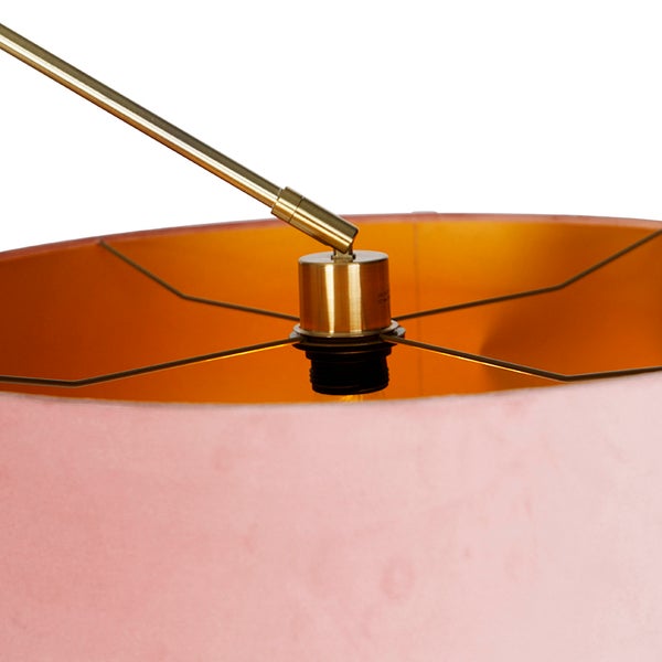 Detailansicht eines Lampenschirms mit rosa Stoffbezug und goldener Innenseite, montiert an einem messingfarbenen Metallarm.