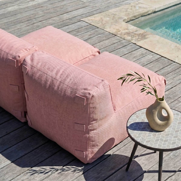 Rosa Outdoor-Sitzsack aus Stoff auf einer Holzterrasse am Pool mit Beistelltisch und Vase.