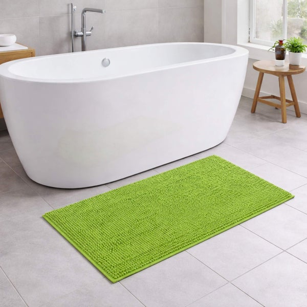 Hellgrüner Chenille-Badteppich vor einer freistehenden weißen Badewanne in einem modern gefliesten Badezimmer.
