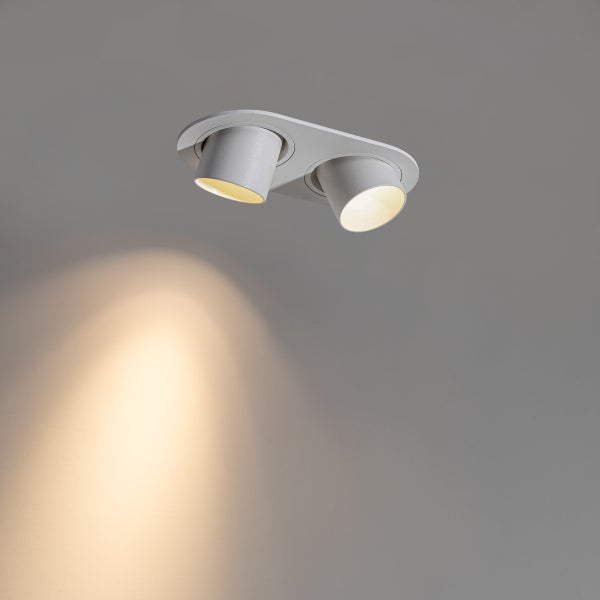 Zweiflammiger Deckenstrahler in Weiß mit schwenkbaren zylindrischen Spotköpfen und warmweißem Lichtkegel.