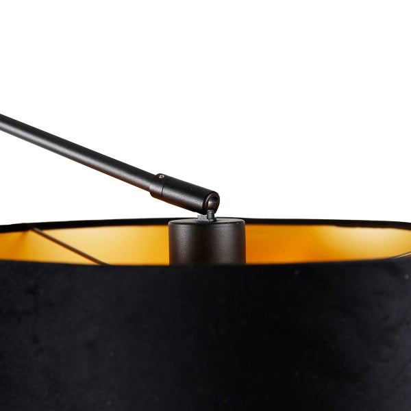 Detailaufnahme einer schwarzen Stehlampe mit verstellbarem Arm und goldfarbenem Lampenschirm