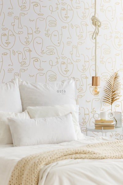 Schlafzimmer mit Tapete mit Gesichtsmuster, Bett, Nachttischlampe und Dekorationen für ein stilvolles Ambiente
