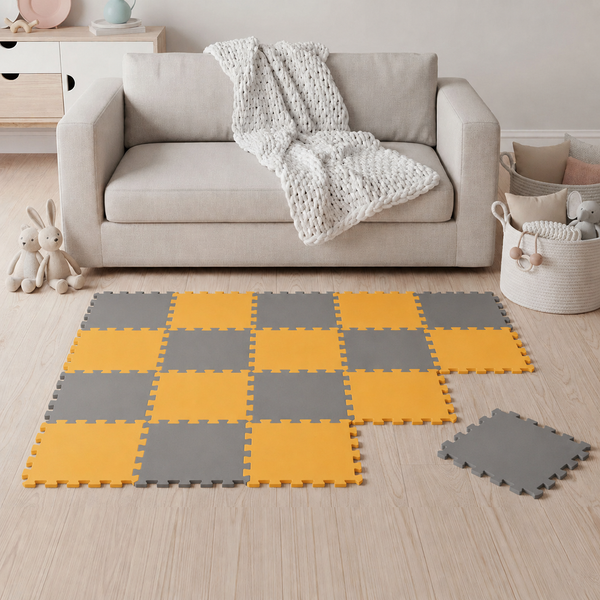 Spielmatte aus Schaumstoff in Puzzleoptik als Bodenbelag für Kinderzimmer mit abwechselnden quadratischen Elementen vor einem Sofa