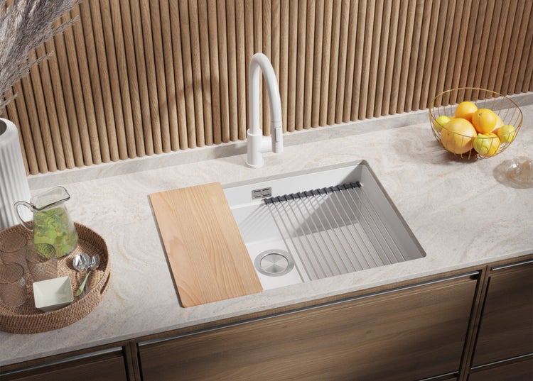 Küchenspüle mit Abtropfgestell, Schneidebrett und Armatur auf einer Küchentheke