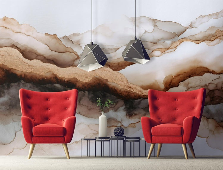 Innenraum mit zwei roten Sesseln, Couchtischen, abstrakter Wandkunst und geometrischen Pendelleuchten.