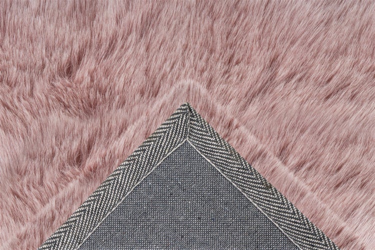 Nahaufnahme eines Kunstfellteppichs mit Langflor und gemusterter Rückseite.