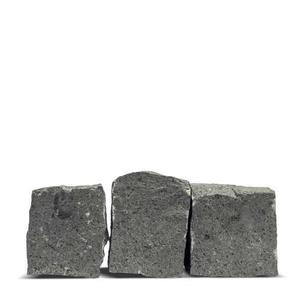 Drei Pflastersteine aus Basalt mit bruchrauer Oberfläche.