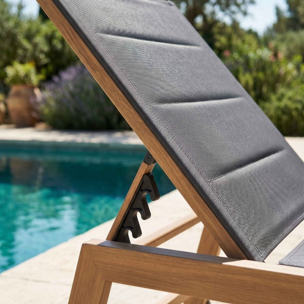 Verstellbare Gartenliege mit Holzrahmen und Textilbespannung am Pool.