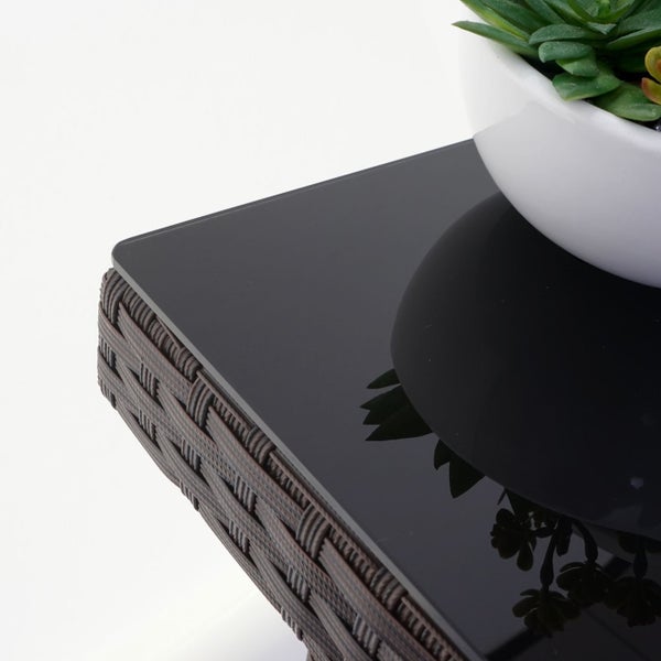 Detailansicht eines Rattantisches mit Glasplatte und Topfpflanze