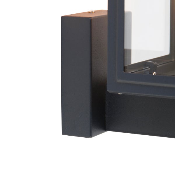 Detailansicht der Wandhalterung und des Rahmens einer Außenleuchte aus Metall und Glas.