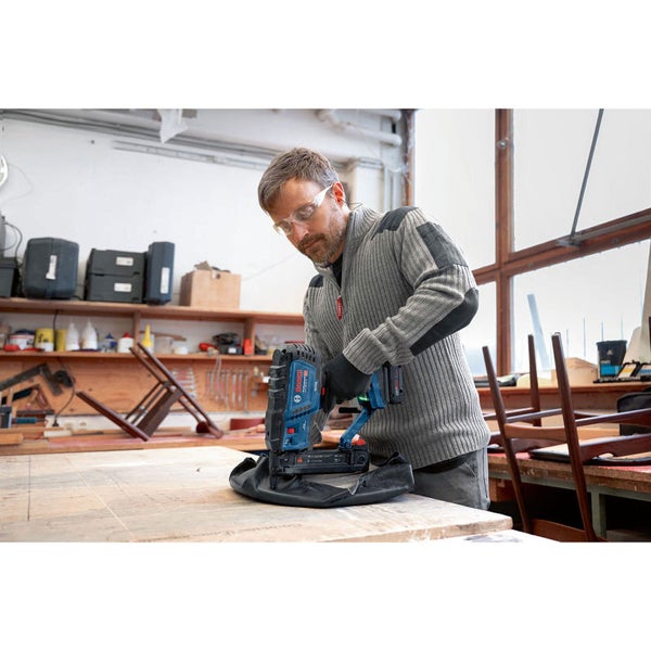 Handwerker in Werkstatt mit Akku-Nagler beim Arbeiten.