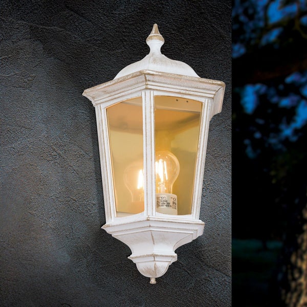 Klassische Außenwandleuchte in Laternenform mit weißer Patina und klarem Glas.