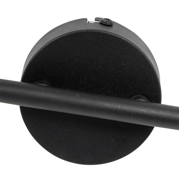 Nahaufnahme einer runden mattschwarzen Wandhalterung aus Metall mit einem horizontalen Arm für eine Leuchte.