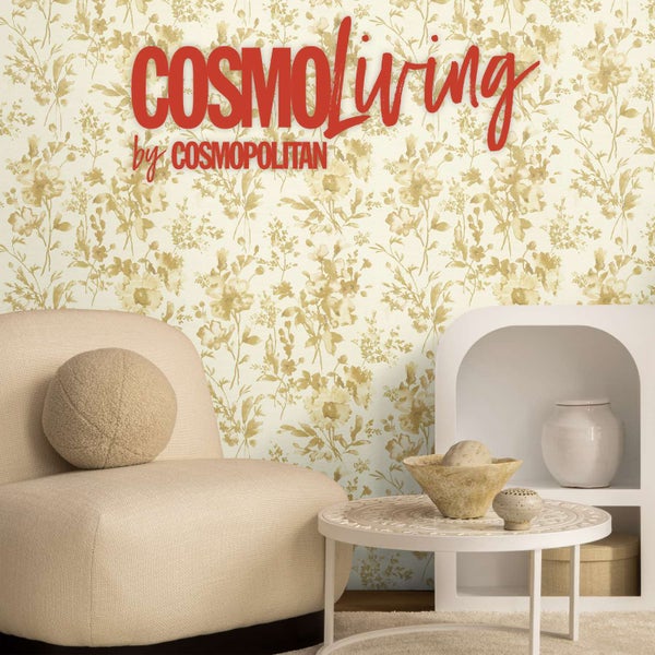 Wohnraum mit CosmoLiving by Cosmopolitan Tapete mit Blumenmuster, modernem Sessel, Couchtisch und dekorativen Wohnaccessoires.