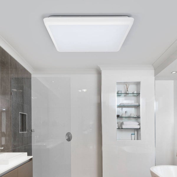 Modernes helles Badezimmer mit einer quadratischen weißen LED-Deckenleuchte, einer Glasduschwand und einem eingebauten Wandregal.