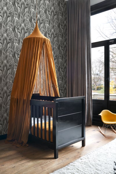 Zimmer mit Babybett, Baldachin und gemusterter Tapete