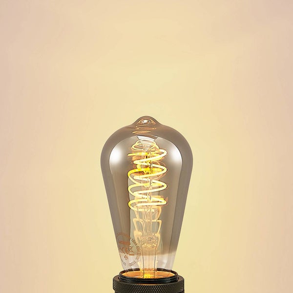 LED-Leuchtmittel in ST64 Edison-Form mit Rauchglas und einer leuchtenden warmgelben Spiral-Filament-LED.