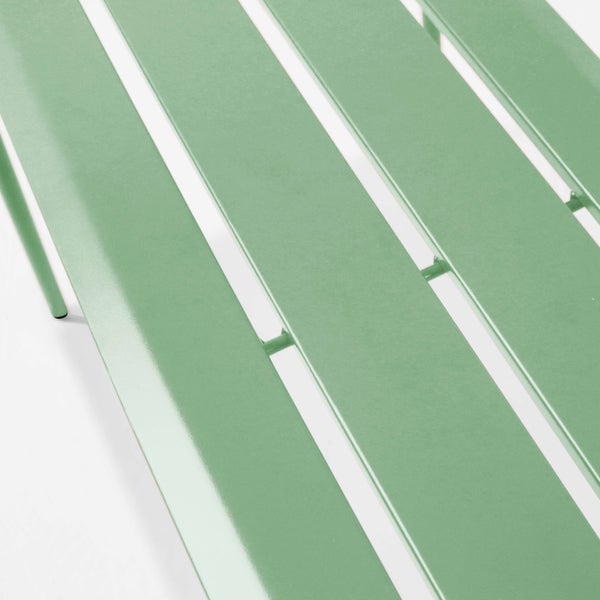 Nahaufnahme der grünen Metalllatten eines Gartenmöbelstücks.